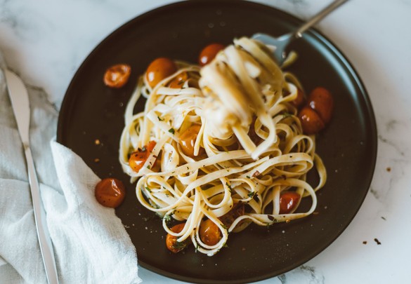 Pasta met tomaat op een donker bord — sfeerbeeld