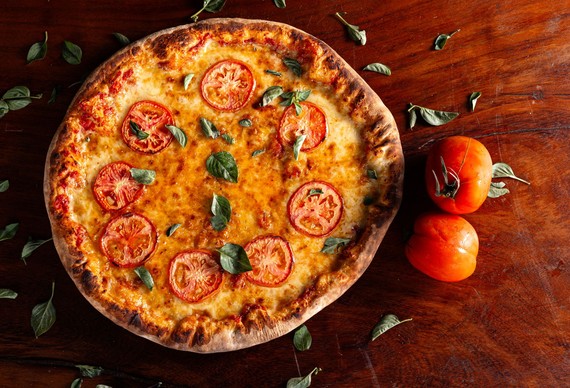 Pizza met tomaat en basilicum — sfeerbeeld