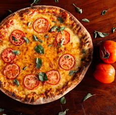 Pizza met tomaat en basilicum — sfeerbeeld