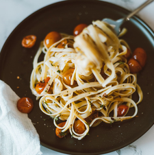Pasta met tomaat op een donker bord — sfeerbeeld